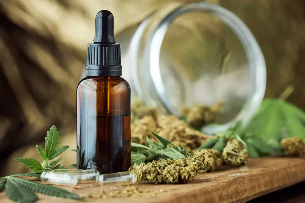 Organic CBD oil with dried CBD leaved and glass jar.