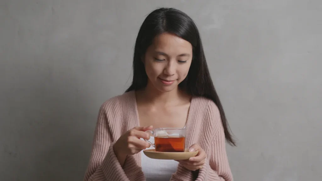 Lady is having a cup of green tea.