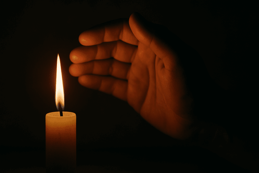 Hand shielding a flickering candle flame in the dark, symbolizing fragile motivation and how to get motivated to lose weight